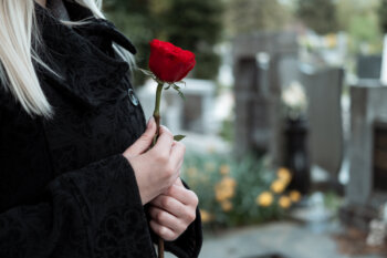 Woman with red flower at cemetery