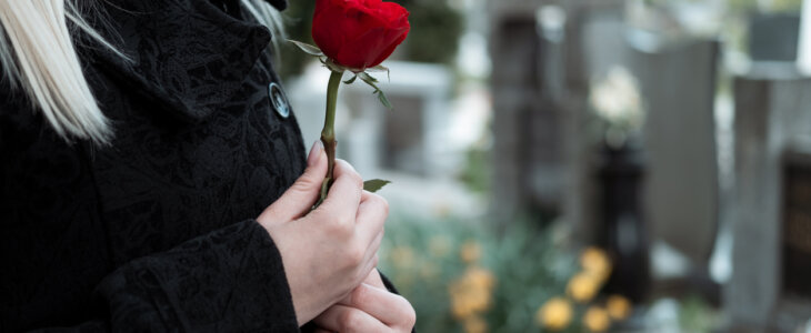 Woman with red flower at cemetery