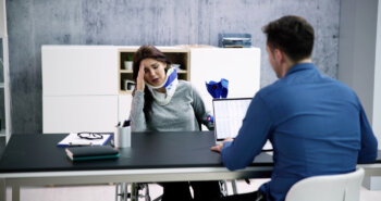 Injured woman with neck brace and injury lawyer meeting