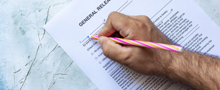 Person's hand filling out a general liability waiver