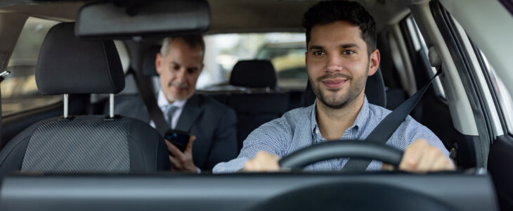 Happy Latin American crowdsourced taxi driver transporting a business man - transportation concepts