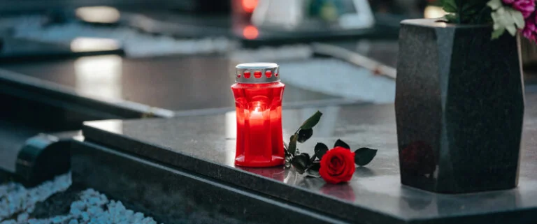 Red candle sitting on a gravesite