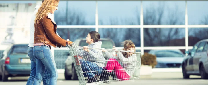 mom pushing children in shopping cart