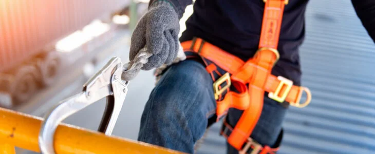 Construction worker use safety harness and safety line working on a new construction site project.